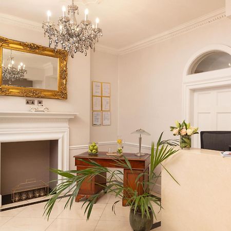 Montcalm Brewery Townhouse Hotel London Bagian luar foto The photo shows a stylish reception area. There is a decorative chandelier hanging from the ceiling, providing elegant lighting. A large, ornate mirror is mounted on the wall beside the fireplace, which features a simple, classic design. In front of 